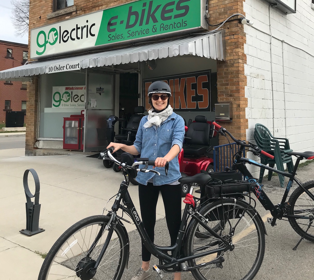 Jamie standing with an e-bike in front of an e-bike store